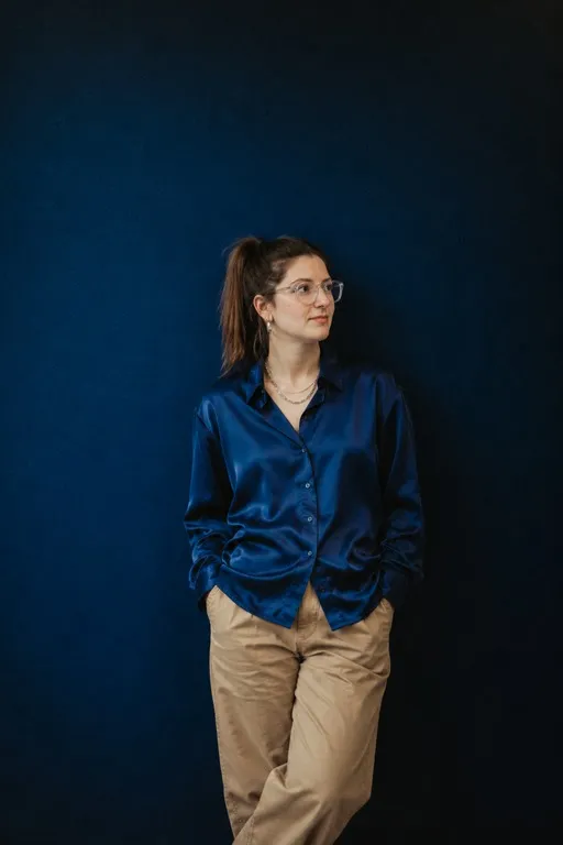 Lena Kühnle in dunkelblauer Bluse vor einer blauen Wand
